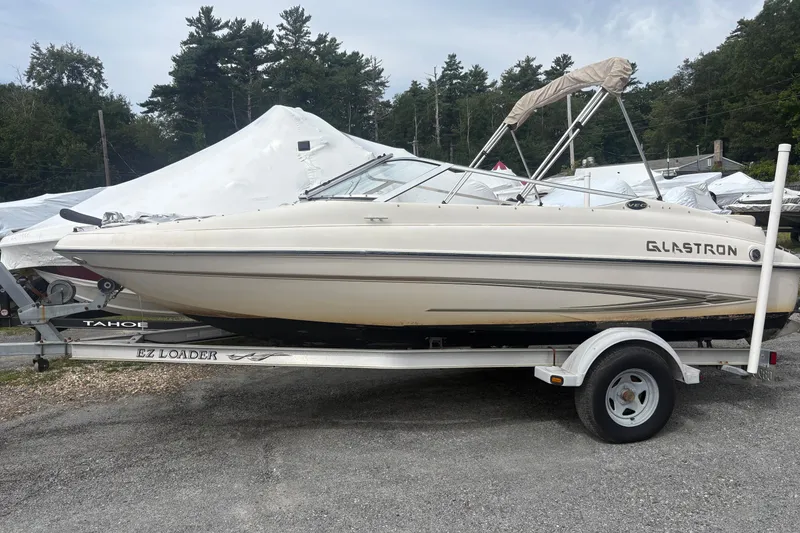 Slide: The Image of 2005 Glastron SX 175 boat on trailer, parked outdoors with trees in background. - 4