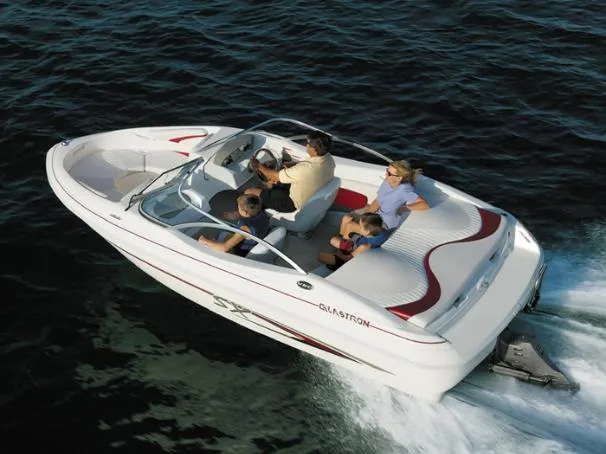 Slide: The Image of 2005 Glastron SX 175 boat interior with beige seating and windshield in a garage setting. - 7