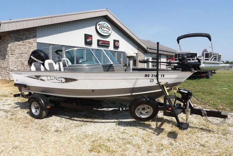 Slide: The Image of 2012 Lund 1775 Impact Sport boat on trailer outside marine center. - 1