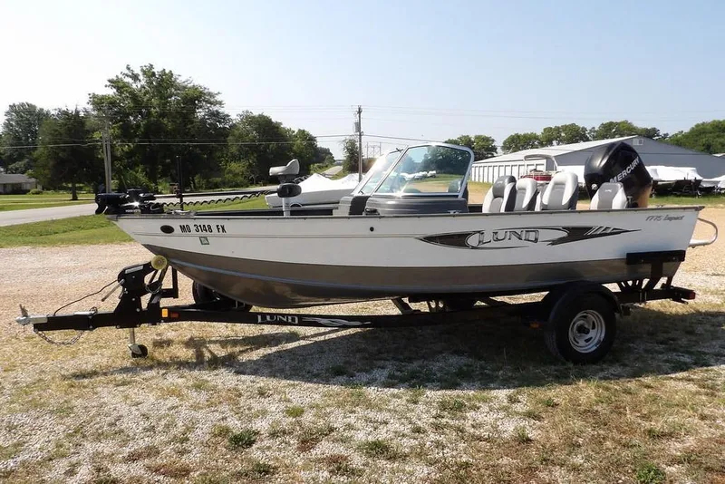 Slide: The Image of 2012 Lund 1775 Impact Sport boat on trailer, parked outdoors. - 2