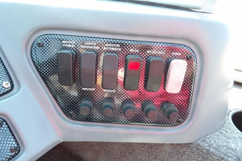 Slide: The Image of Control panel of a 2012 Lund 1775 Impact Sport boat with various switches and knobs. - 30
