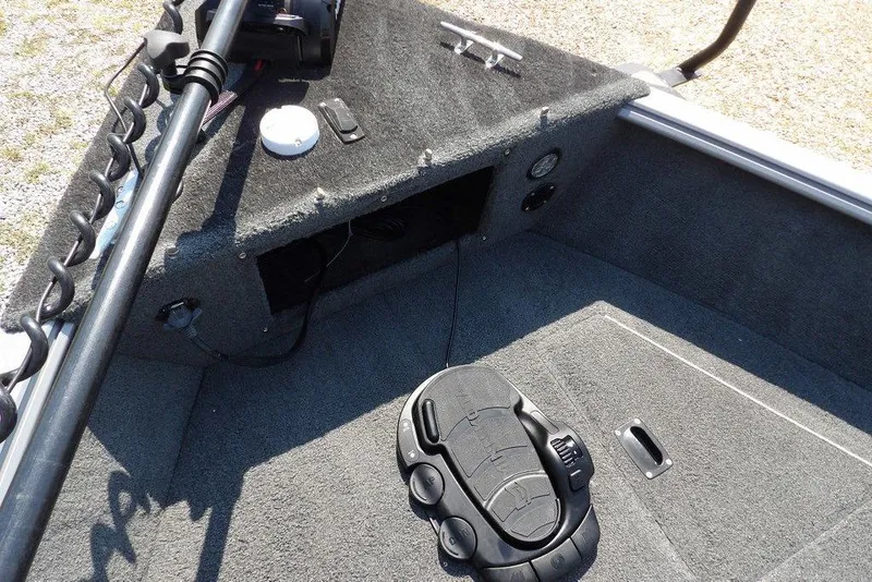 Slide: The Image of Interior of a 2012 Lund 1775 Impact Sport boat, featuring carpeted flooring and control panel. - 49