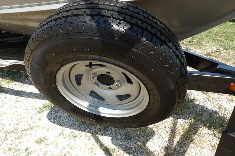 Slide: The Image of 2012 Lund 1775 Impact Sport trailer tire on gravel surface. - 56