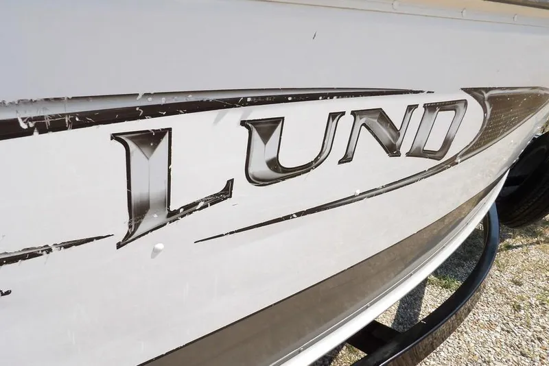 Slide: The Image of 2012 Lund 1775 Impact Sport boat logo on white hull. - 60