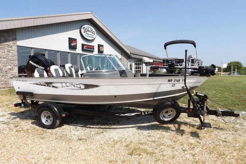 Slide: The Image of 2012 Lund 1775 Impact Sport boat on trailer outside marine center. - 67