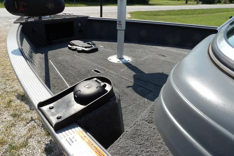 Slide: The Image of 2012 Lund 1775 Impact Sport boat interior with carpeted deck and storage compartments. - 7