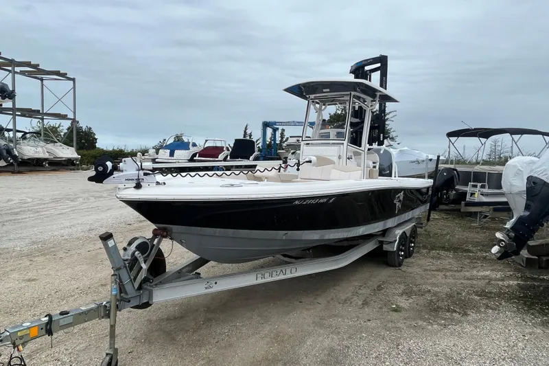 Slide: The Image of 2016 Robalo 246 Cayman boat on trailer in outdoor storage area. - 1