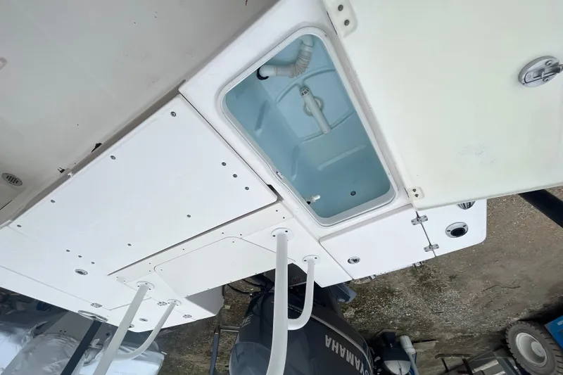 Slide: The Image of 2016 Robalo 246 Cayman boat deck with open storage compartment and Yamaha engine. - 15