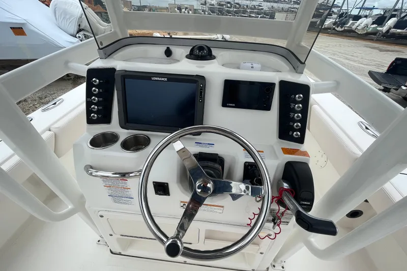 Slide: The Image of 2016 Robalo 246 Cayman boat dashboard with steering wheel and navigation controls. - 19