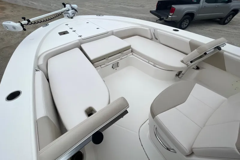 Slide: The Image of 2016 Robalo 246 Cayman boat interior with white seating and fishing equipment. - 22