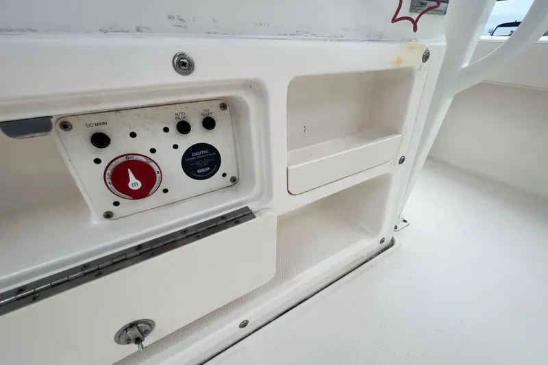 Slide: The Image of 2016 Robalo 246 Cayman boat control panel with storage compartments. - 24