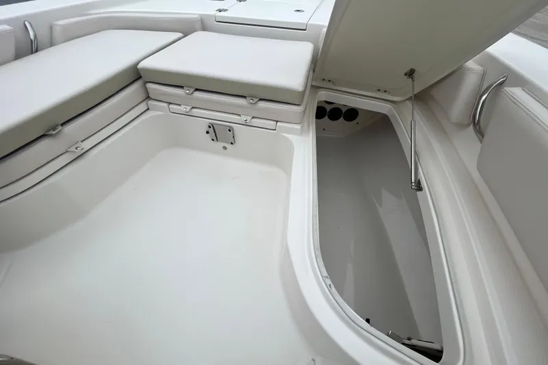 Slide: The Image of 2016 Robalo 246 Cayman boat interior with open storage compartment and cushioned seating. - 27