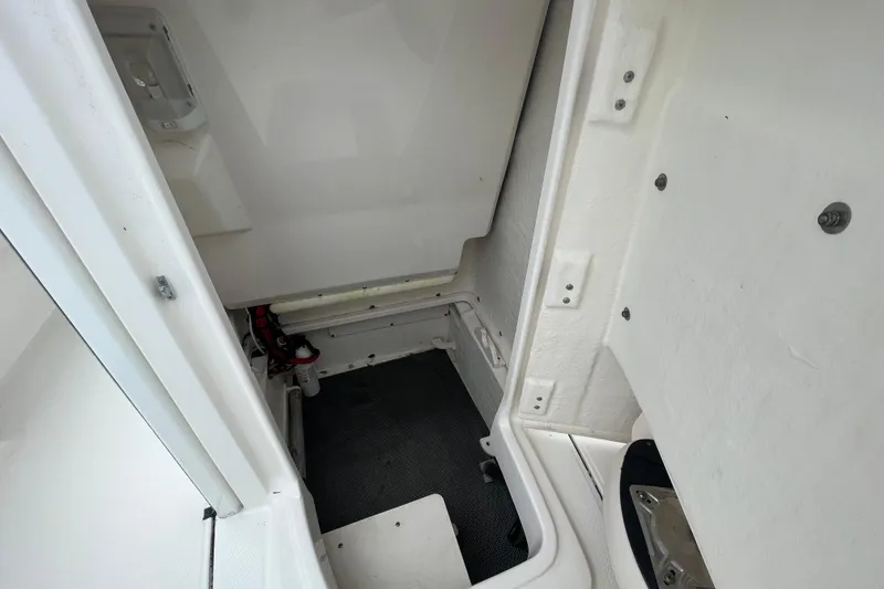 Slide: The Image of 2016 Robalo 246 Cayman interior compartment, featuring clean white surfaces and storage space. - 33