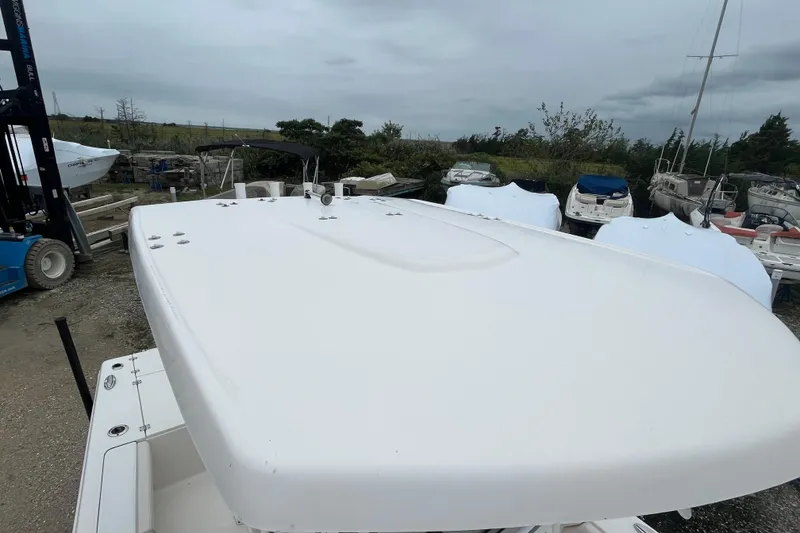 Slide: The Image of 2016 Robalo 246 Cayman boat on land, surrounded by other covered boats. - 37