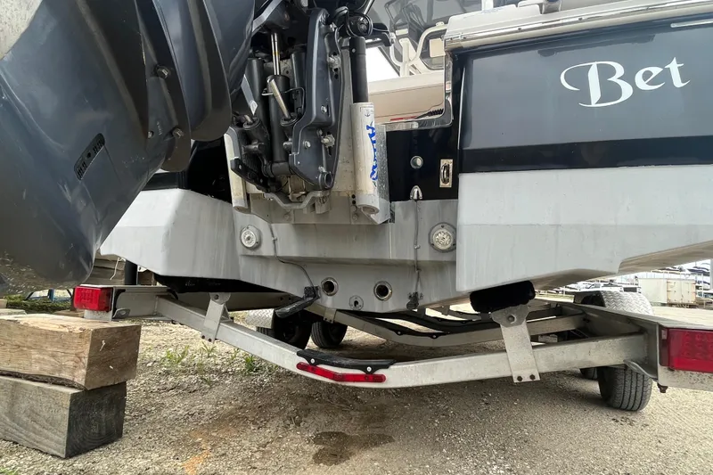 Slide: The Image of 2016 Robalo 246 Cayman boat on trailer, rear view showing engine and hull details. - 4