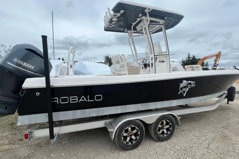 Slide: The Image of 2016 Robalo 246 Cayman boat on trailer with Yamaha engine, parked outdoors. - 7
