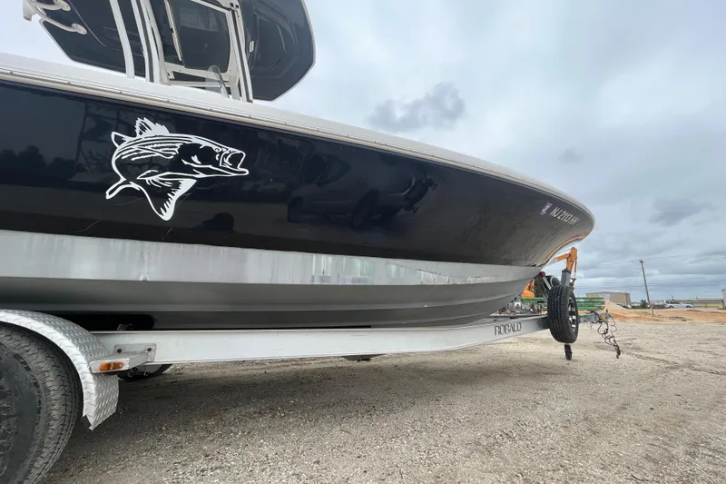 Slide: The Image of 2016 Robalo 246 Cayman boat on trailer, featuring sleek black hull design. - 8
