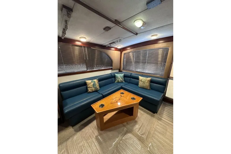Slide: The Image of Interior of 1986 Ocean Yachts 38 Super Sport with blue seating and wooden table. - 10