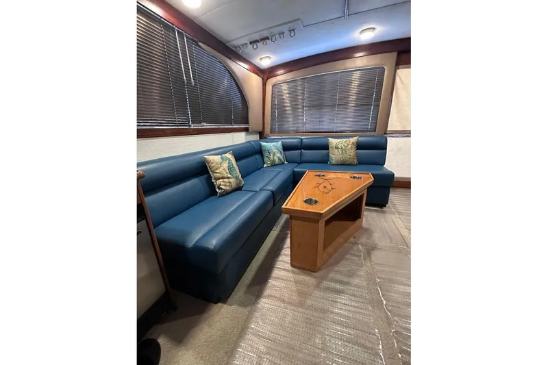 Slide: The Image of Interior of 1986 Ocean Yachts 38 Super Sport with blue seating and wooden table. - 11