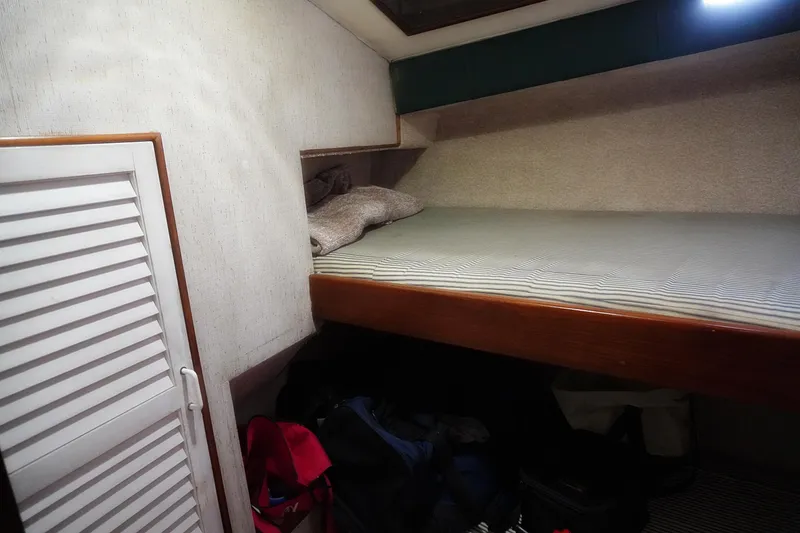 Slide: The Image of 1986 Ocean Yachts 38 Super Sport cabin interior with bed and storage space. - 24