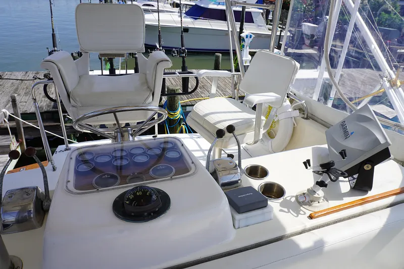 Slide: The Image of 1986 Ocean Yachts 38 Super Sport cockpit with helm, seating, and navigation equipment. - 5