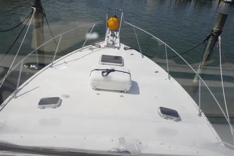 Slide: The Image of 1986 Ocean Yachts 38 Super Sport boat deck with hatches and railing, docked by water. - 6