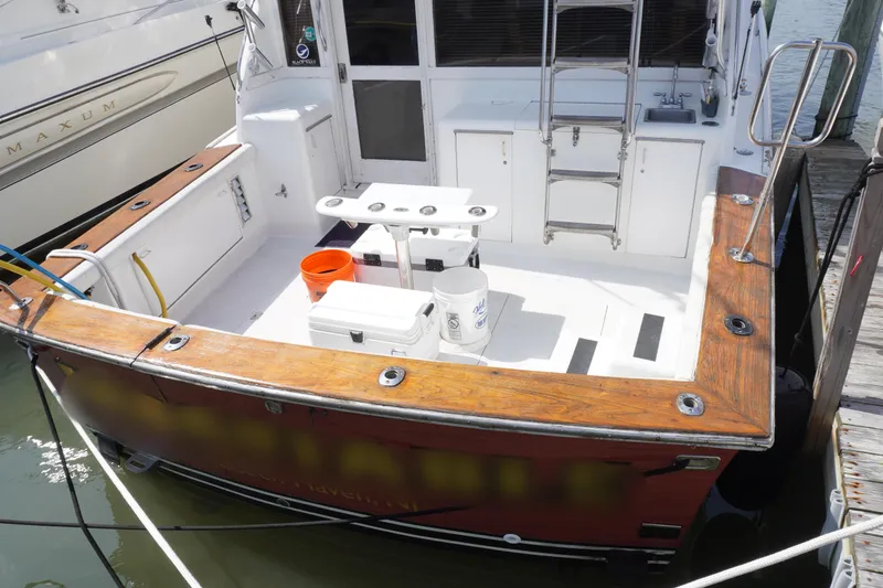 Slide: The Image of 1986 Ocean Yachts 38 Super Sport boat docked, featuring spacious deck and fishing equipment. - 7