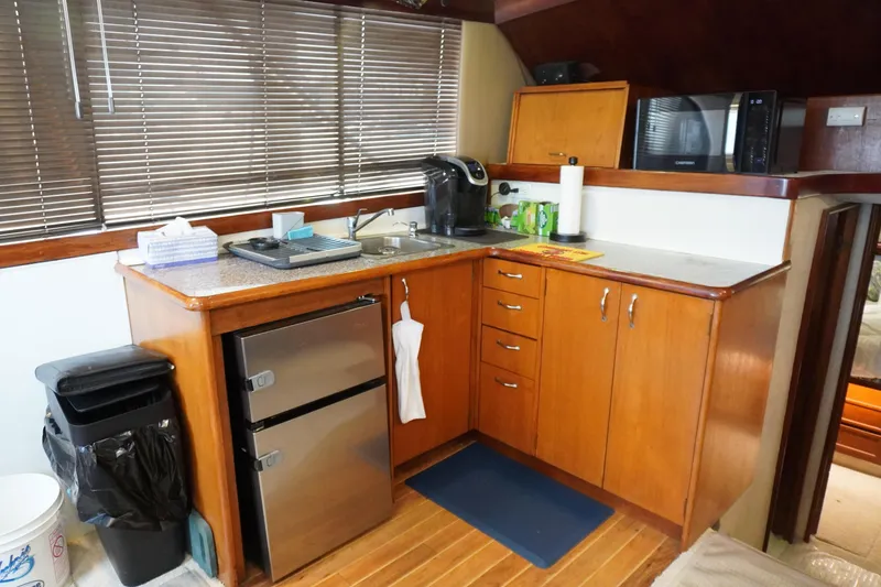 Slide: The Image of 1986 Ocean Yachts 38 Super Sport kitchen with wooden cabinets and modern appliances. - 14