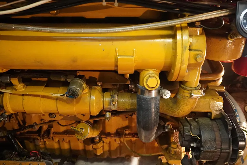 Slide: The Image of Engine components of a 1986 Ocean Yachts 38 Super Sport, featuring yellow machinery and hoses. - 16