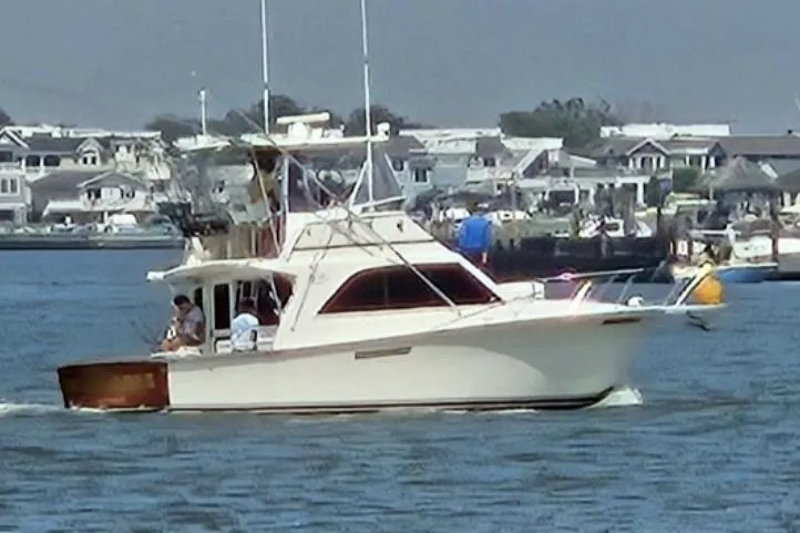 Slide: The Image of 1986 Ocean Yachts 38 Super Sport cruising near coastal homes. - 2