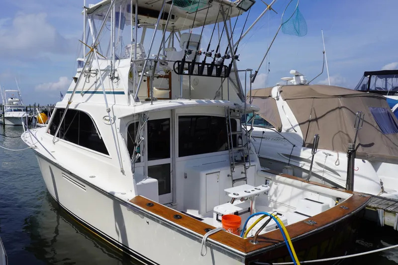 Slide: The Image of 1986 Ocean Yachts 38 Super Sport docked, featuring fishing equipment and spacious deck. - 8