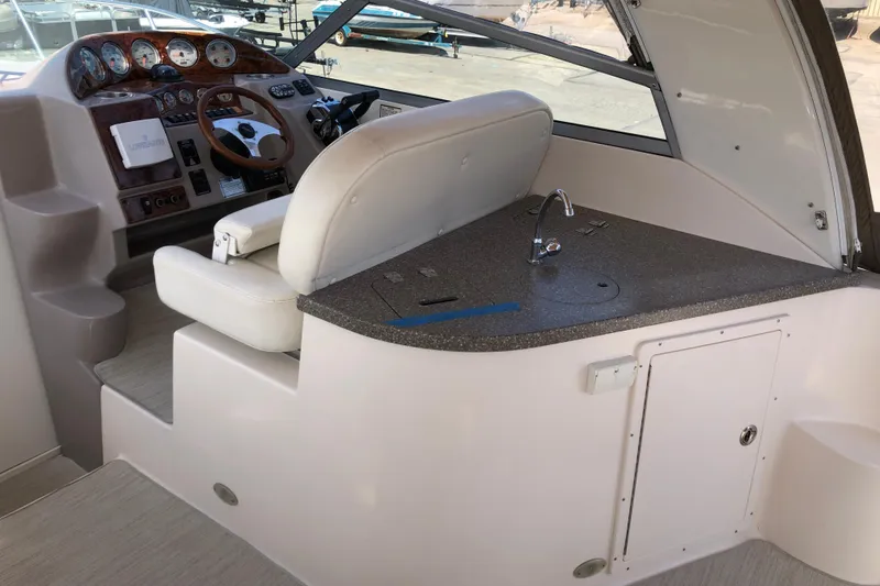 Slide: The Image of 2004 Rinker Fiesta Vee 312 boat interior with helm and kitchenette area. - 13