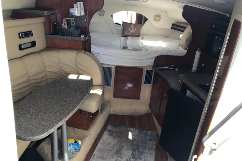 Slide: The Image of 2004 Rinker Fiesta Vee 312 cabin interior with seating, table, and bed. - 17