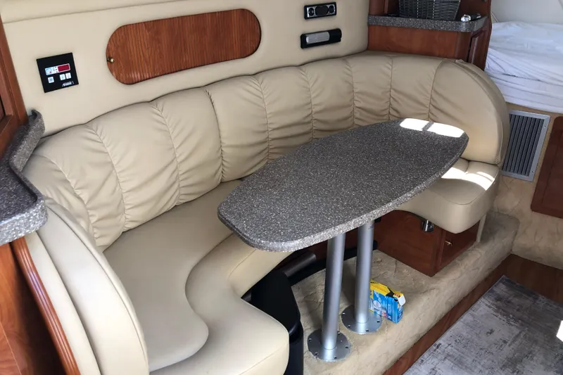 Slide: The Image of 2004 Rinker Fiesta Vee 312 interior with beige leather seating and a granite-style table. - 18