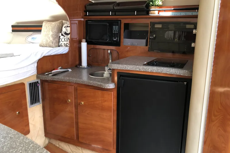 Slide: The Image of 2004 Rinker Fiesta Vee 312 cabin kitchen with sink, microwave, and fridge. - 19