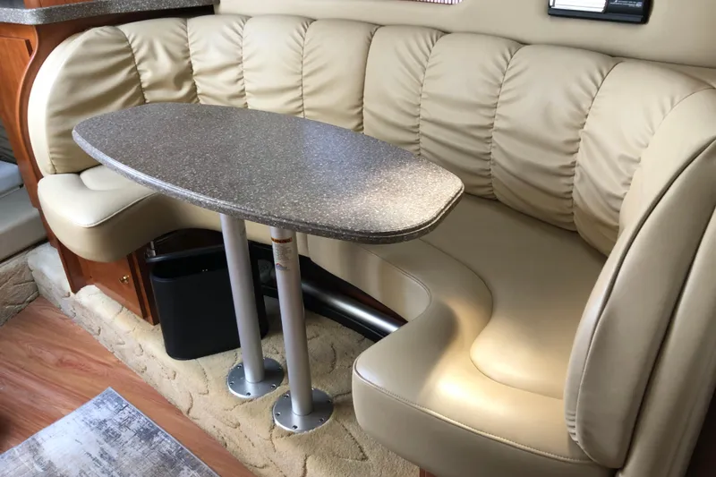 Slide: The Image of 2004 Rinker Fiesta Vee 312 interior with beige leather seating and oval table. - 21