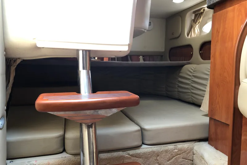 Slide: The Image of 2004 Rinker Fiesta Vee 312 cabin interior with cushioned seating and wooden accents. - 23