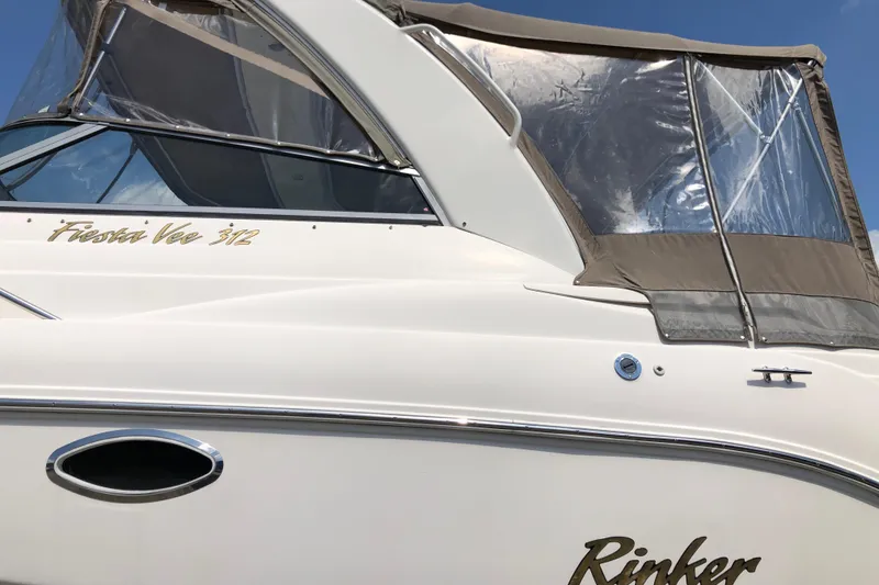 Slide: The Image of 2004 Rinker Fiesta Vee 312 boat with canopy and sleek design. - 4
