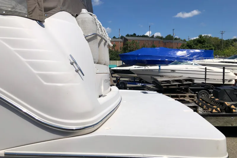 Slide: The Image of 2004 Rinker Fiesta Vee 312 boat docked, with other boats in the background under blue sky. - 5