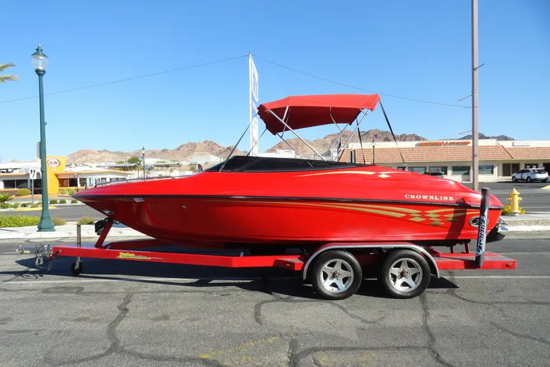 Slide: The Image of Red 2000 Crownline 202 BR LPX boat on trailer, parked in urban setting. - 1