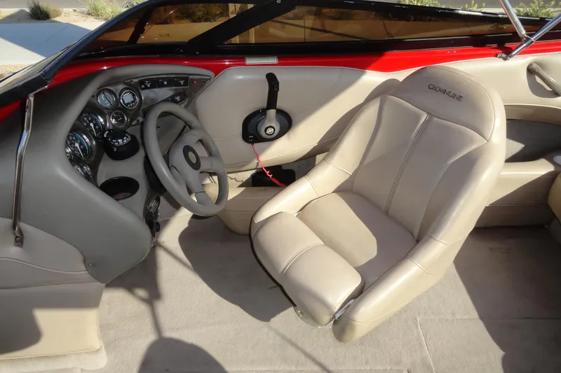 Slide: The Image of Interior of a 2000 Crownline 202 BR LPX boat with beige seating and dashboard controls. - 10