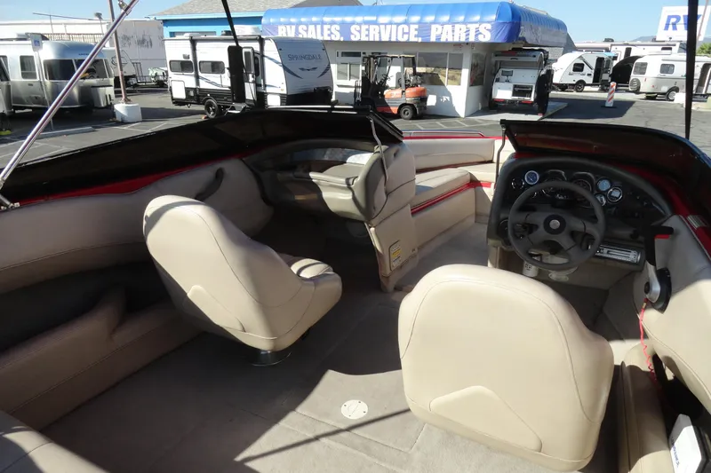 Slide: The Image of Interior of a 2000 Crownline 202 BR LPX boat with beige seating and dashboard. - 13