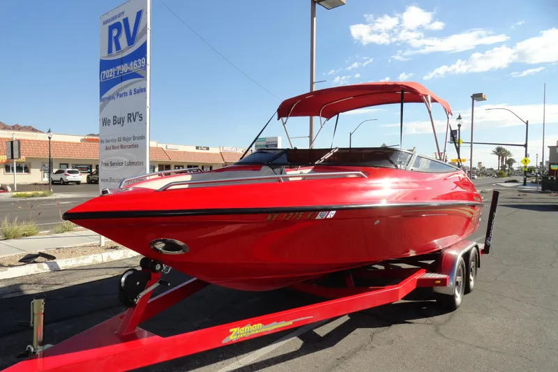 Slide: The Image of Red 2000 Crownline 202 BR LPX boat on trailer, parked near RV dealership. - 2