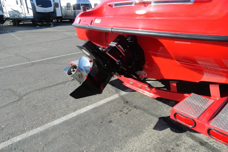 Slide: The Image of Red 2000 Crownline 202 BR LPX boat with visible propeller and trailer in parking lot. - 21