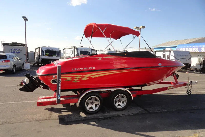 Slide: The Image of Red 2000 Crownline 202 BR LPX boat on trailer, parked in dealership lot. - 4