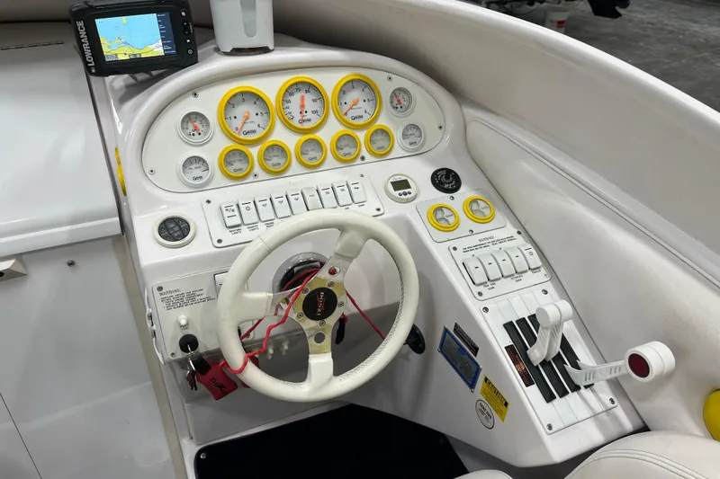 Slide: The Image of 1999 Donzi 28 ZX boat dashboard with gauges, steering wheel, and navigation system. - 10