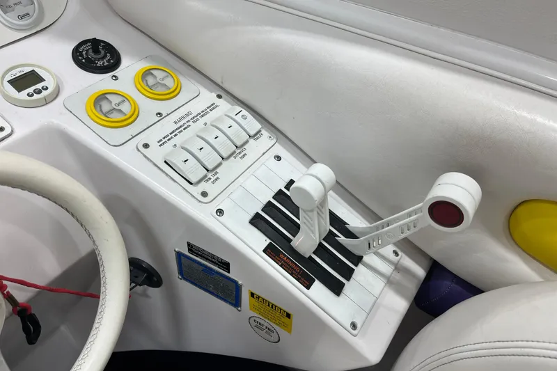 Slide: The Image of 1999 Donzi 28 ZX boat control panel with steering wheel and throttle levers. - 11