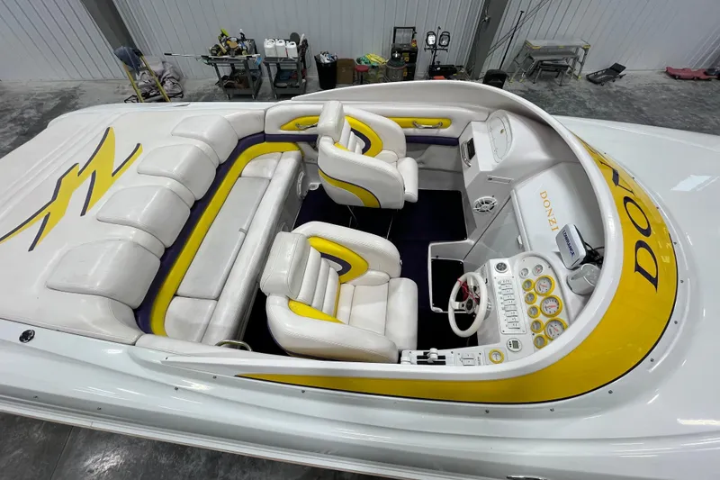 Slide: The Image of 1999 Donzi 28 ZX boat interior with white and yellow seating, dashboard, and controls. - 8