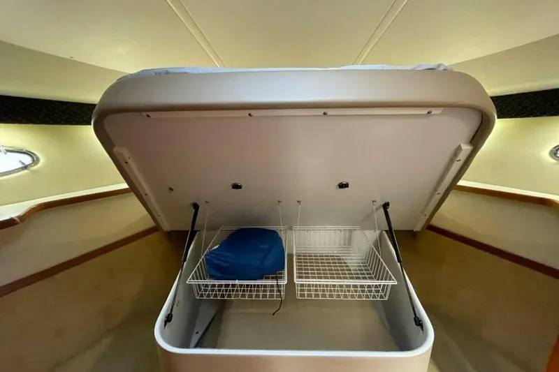 Slide: The Image of Under-bed storage in 2000 Tiara 41 Open yacht, featuring wire baskets and hydraulic lifts. - 17