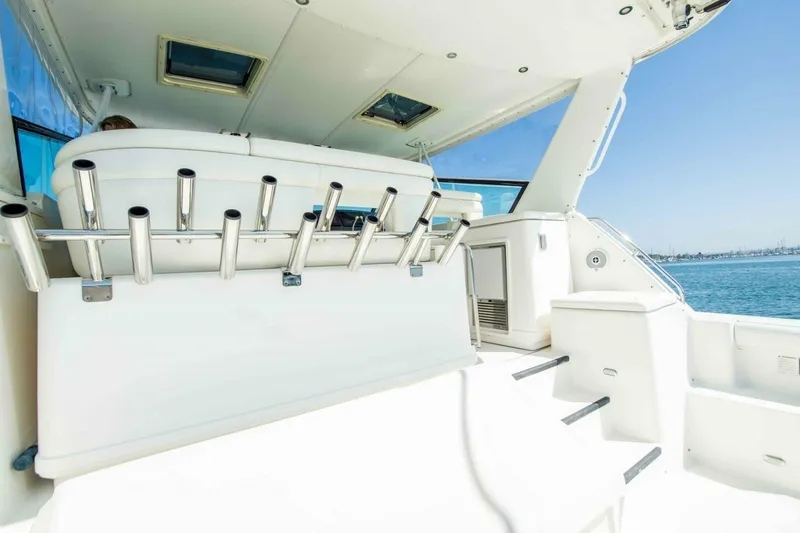 Slide: The Image of 2000 Tiara 41 Open yacht interior with rod holders, overlooking serene blue waters. - 22